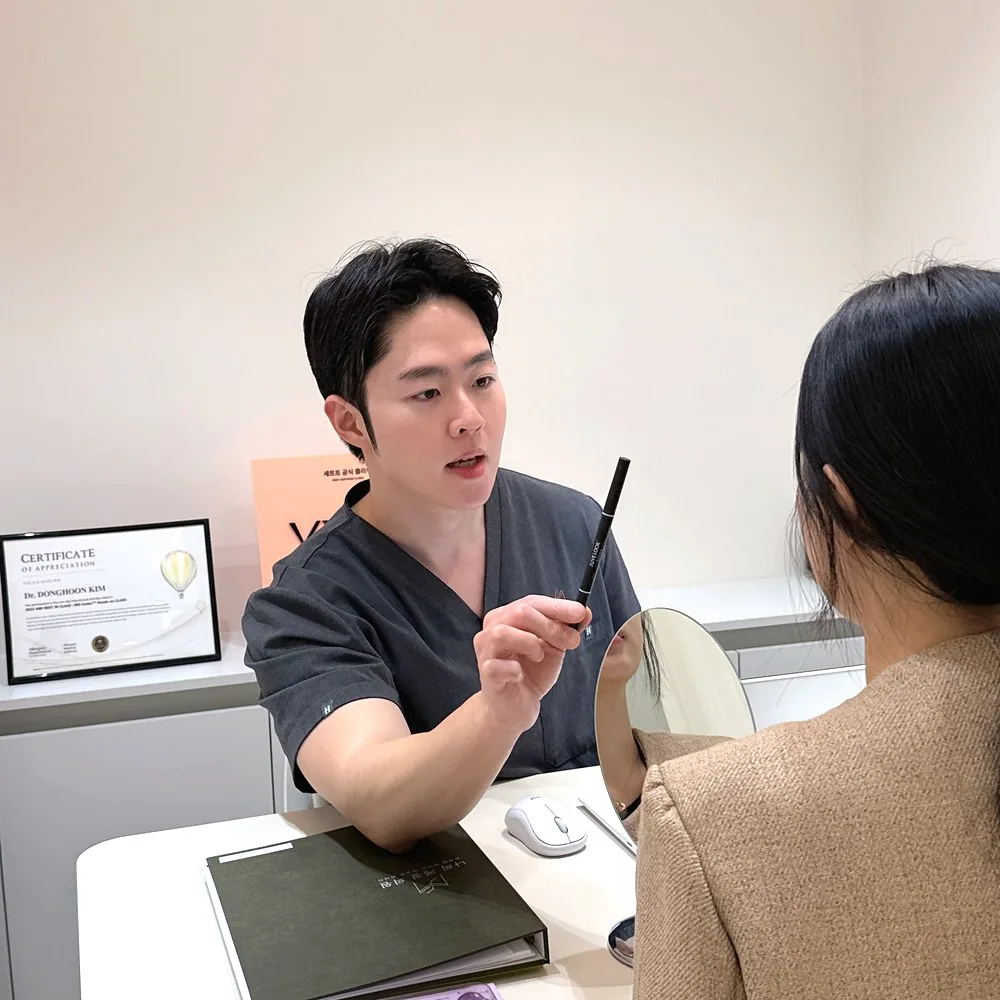 나의계절의원 울산 대표원장이 거울을 보며 이마 윤곽을 상담하는 모습